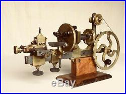 Antique watchmaker or jeweler big brass lathe on wooden stand vintage tool