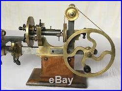 Antique watchmaker or jeweler big brass lathe on wooden stand vintage tool
